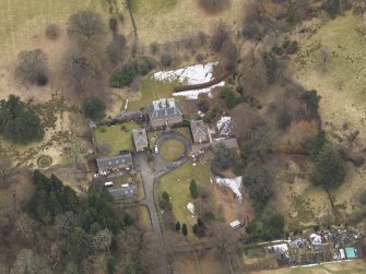 Oblique aerial view centred on the country house with the stable block, taken from the NNW.