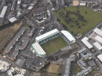 Oblique aerial view centred on the stadium with the half demolished E stand adjacent, taken from the ESE.