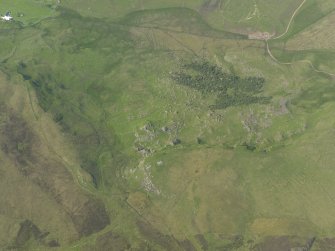 Oblique aerial view of the remains of the buildings and field banks, taken from the S.