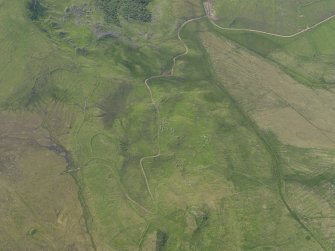 Oblique aerial view of the remains of the buildings and field banks, taken from the E.