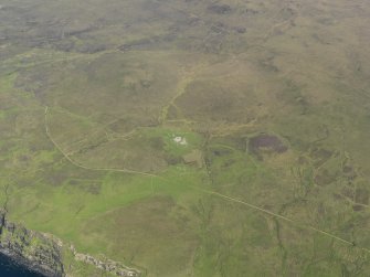 General oblique aerial view of the remains of Dun Gearymore broch, the field system and buildings, taken from the W.