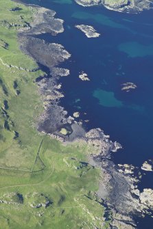 General oblique aerial view centred on the remains of the fort and the township buildings at Dun Ara, taken from the NE.