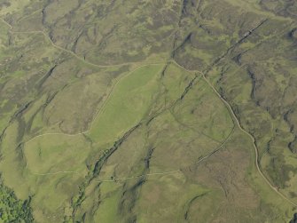 Oblique aerial view of the remains of the township buildings at Portnabhata with the road running past, taken from the WNW.