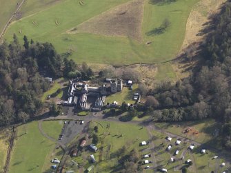 Oblique aerial view centred on the country house with the caravan park adjacent, taken from the W.
