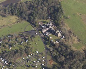 Oblique aerial view centred on the country house with the caravan park adjacent, taken from the SSW.