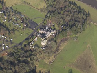 Oblique aerial view centred on the country house with the caravan park adjacent, taken from the SE.