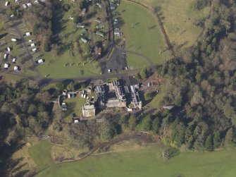 Oblique aerial view centred on the country house with the caravan park adjacent, taken from the E.