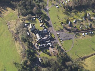 Oblique aerial view centred on the country house with the caravan park adjacent, taken from the N.