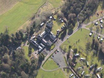 Oblique aerial view centred on the country house with the caravan park adjacent, taken from the NW.