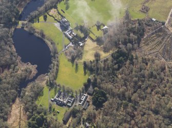 General oblique aerial view centred on the country house with the stables adjacent, taken from the NW.