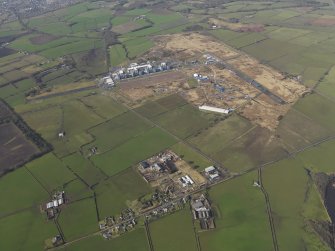 General oblique aerial view centred on the village with the Nuclear power station and airfield adjacent, taken from the ENE.