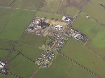 Oblique aerial view centred on the village with the airfield domestic site adjacent, taken from the SE.