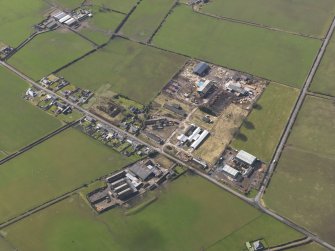 Oblique aerial view centred on the village with the airfield domestic site adjacent, taken from the NNE.