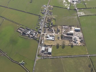 Oblique aerial view centred on the village with the airfield domestic site adjacent, taken from the NW.