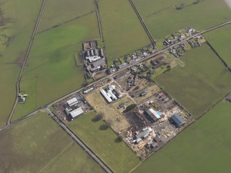 Oblique aerial view centred on the village with the airfield domestic site adjacent, taken from the SW.