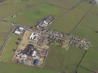 Oblique aerial view centred on the village with the airfield domestic site adjacent, taken from the SSW.