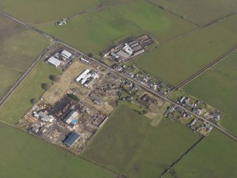 Oblique aerial view centred on the village with the airfield domestic site adjacent, taken from the SSW.