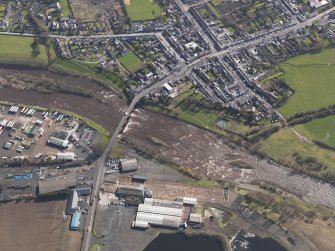 General oblique aerial view centred on the town with the site of the railway bridge adjacent , taken from the NW.