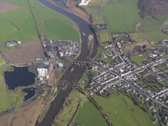 General oblique aerial view centred on the town with the site of the railway bridge adjacent , taken from the S.