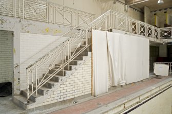 Interior. View of main stair linking poolside and balcony within pool hall.