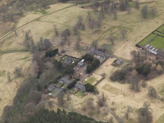 Oblique aerial view centred on the stables with the laundry adjacent, taken from the NNE.