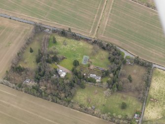 Oblique aerial view centred on the country house with the  walled garden, gate-lodges and cottage adjacent, taken from the NW.