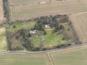 Oblique aerial view centred on the country house with the  walled garden, gate-lodges and cottage adjacent, taken from the SSE.