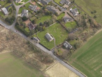 Oblique aerial view centred on the church with the tithe barn adjacent, taken from the NW.