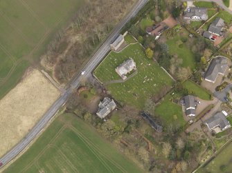 Oblique aerial view centred on the church with the tithe barn adjacent, taken from the SW.