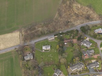 Oblique aerial view centred on the church with the tithe barn adjacent, taken from the SSW.