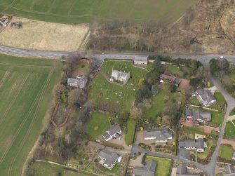 Oblique aerial view centred on the church with the tithe barn adjacent, taken from the S.
