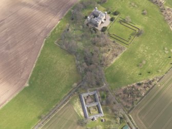 Oblique aerial view centred on the country house with the Home Farm adjacent,  taken from the W.
