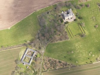 Oblique aerial view centred on the country house with the Home Farm adjacent,  taken from the WSW.