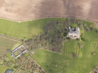 Oblique aerial view centred on the country house with the Home Farm adjacent,  taken from the SW.