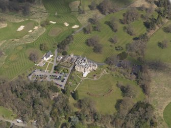 Oblique aerial view centred on the hotel with the stable block adjacent, taken from the S.