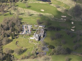 Oblique aerial view centred on the hotel with the stable block adjacent, taken from the E.