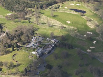 Oblique aerial view centred on the hotel with the stable block adjacent, taken from the E.