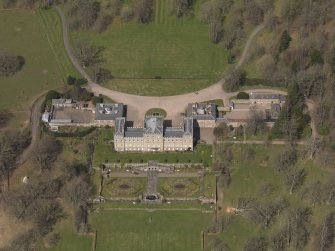 Oblique aerial view centred on the country house with the stable block adjacent, taken from the SE.