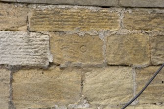 E facade, detail of incised circular mark below ground floor window