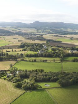 General oblique aerial view of the remains of the recumbent stone circle and enclosed cremation cemetery at Loanhead of Daviot with Mither Tap of Bennachie in the distance, taken from the SW.