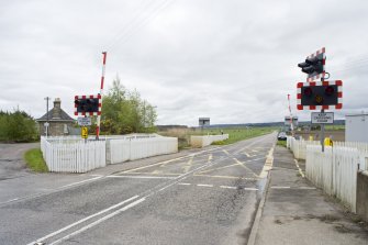 View from NW showing level crosssing and station building.