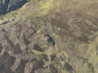 Oblique aerial view centred on Kilphedir Broch with the small cairns and hut-circles adjacent, taken from the S.