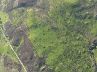 Oblique aerial view of the remains of the hut-circles, small cairns,township and rig, taken from the SSE.