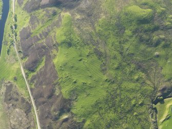 Oblique aerial view of the remains of the hut-circles, small cairns,township and rig, taken from the SE.