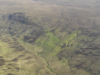 General oblique aerial view of the remains of the buildings, field boundaries, rig and hut-circles at Askaig, taken from the E.