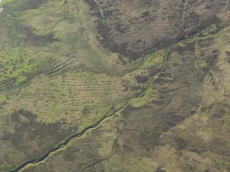 Oblique aerial view of the remains of the buildings, field boundaries and rig and furrow at Wester Badanloch, taken from the ESE.