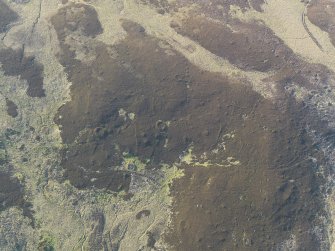 Oblique aerial view of the remains of the hut-circles and small cairns, taken from the SSE.