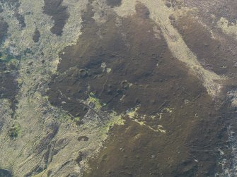 Oblique aerial view of the remains of the hut-circles and small cairns, taken from the SE.