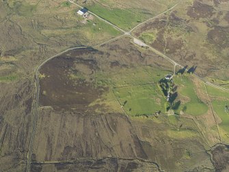 Oblique aerial view of the remains of the hut-circles and small cairns at Dremergid, taken from the W.