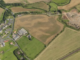 Oblique aerial view of the cropmarks of the round house and pits, taken from the WSW.
